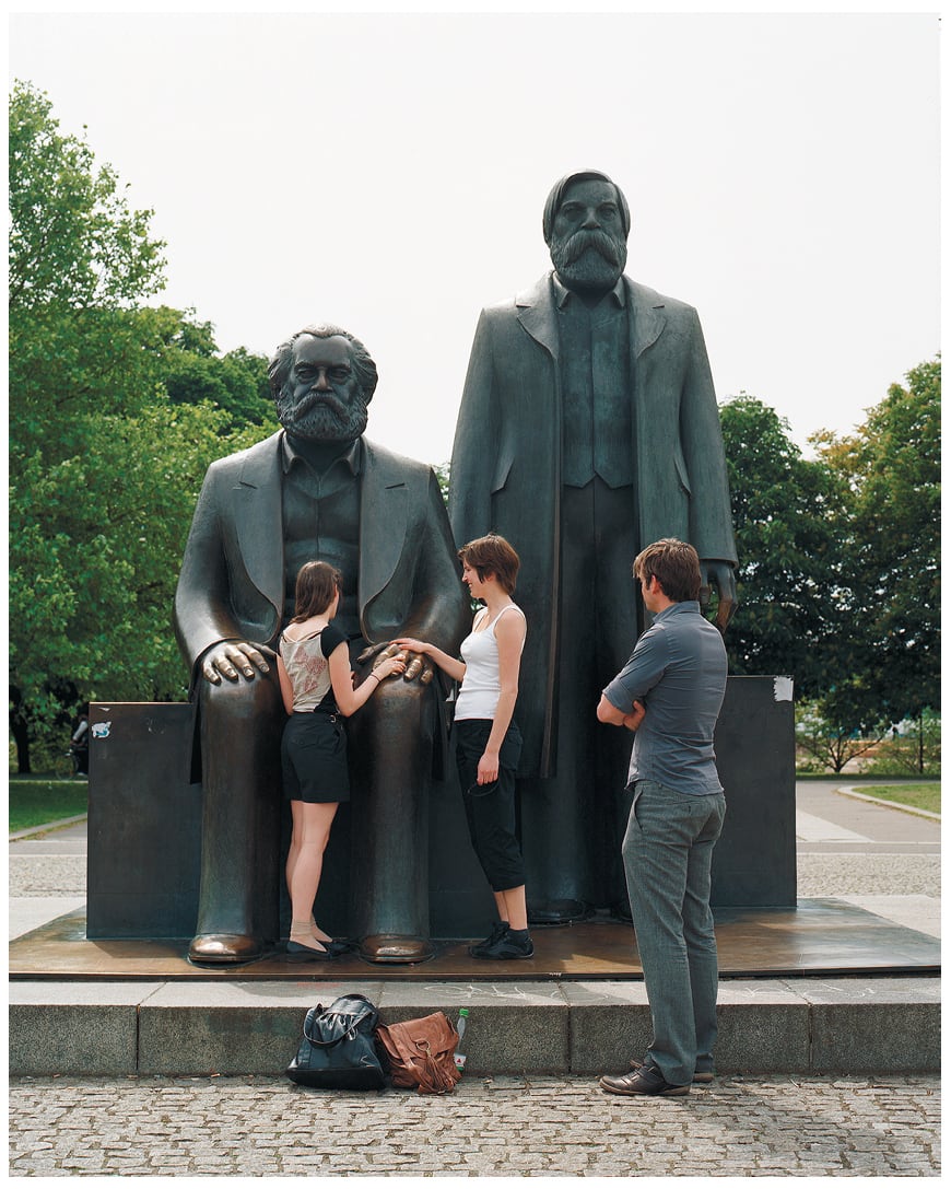 Warren Neidich, <em>Marx and Engels</em>, 2008–2009.‘<em>Marx and Engels</em> is a Soviet-era statue installed in 1986 on Alexanderplatz, Berlin, between the Television Tower and where the Palast der Republik used to stand. It became a set for a series of photographs I made between 2008 and 2009. The fall of the Berlin Wall had both immediate and long-term consequences. This once-important monument depicting two famous philosophical figures has become nothing more than a backdrop for staged photographs by tourists visiting the city, elucidating the ideological changes that have resulted form the fall of communism and the rise of capitalism.’ — Warren Niedich